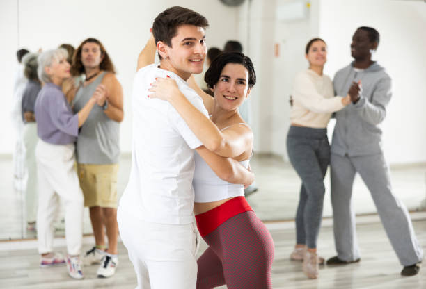istock Guy learning to dance waltz with Hispanic girl in dancing class 1465631827
