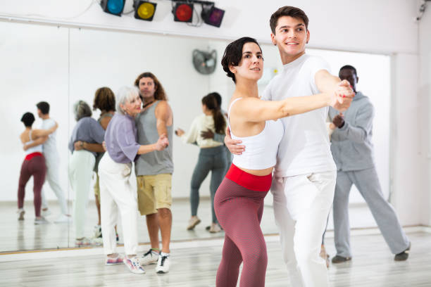 istock Guy learning to dance waltz with Hispanic girl in dancing class 1465632362