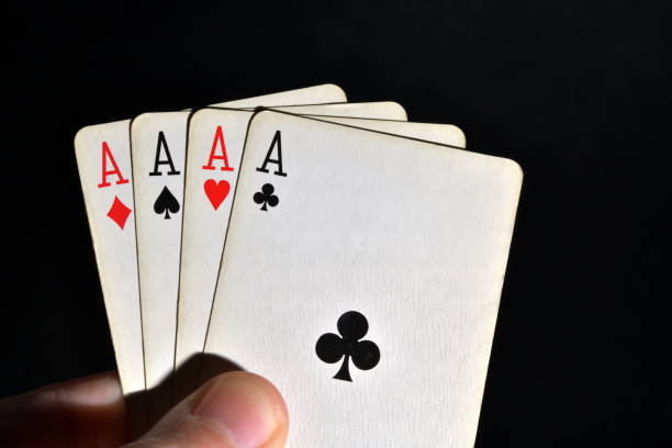 istock Four aces in hand over black background 1465632388