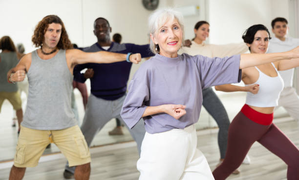 istock Cheerful old lady learning new modern dance in group dance lesson 1465632608