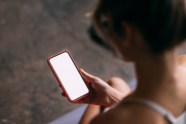 An Unrecognizable Beautiful Woman Watching Something On Her Mobile Phone During Her Training