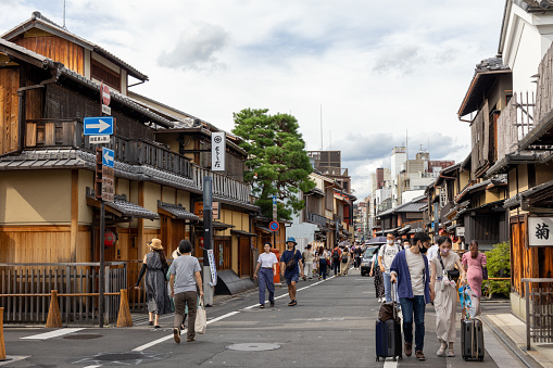 Kyoto, Japan - August 16, 2022: People at Hanamikoji-dori in Kyoto, Japan. It is a famous street near Gion, many souvenir shops, restaurants and tea houses are located in this street.