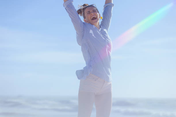 happy stylish woman at the beach jumping.