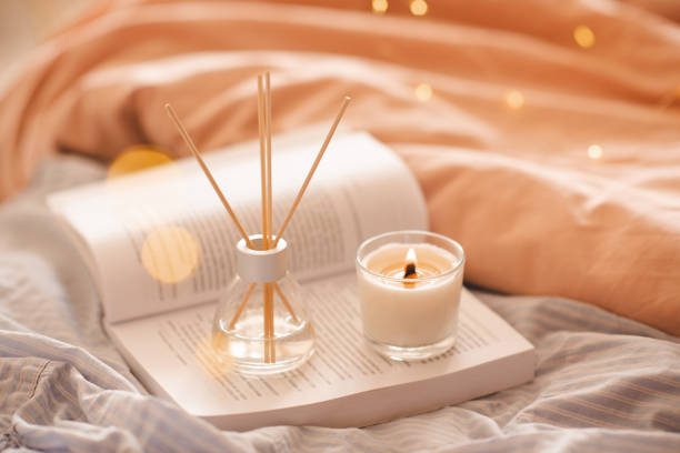 istock Home liquid diffuser with fragrance with candle and open book in bedroom close up 1465647401