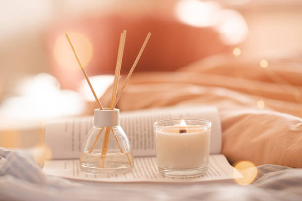 istock Home liquid diffuser with fragrance with candle and open book in bedroom close up 1465647403