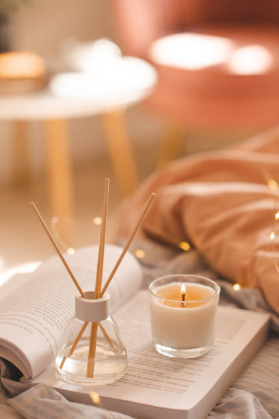 istock Home liquid diffuser with fragrance with candle and open book in bedroom close up 1465647421