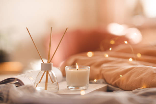 istock Home liquid diffuser with fragrance with candle and open book in bedroom close up 1465647535