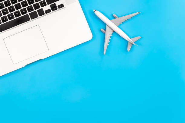istock Laptop and airplane miniature on blue background, flat lay, copy space. 1465649611
