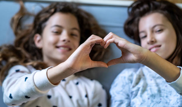 istock Sisters make a heart with their hands. 1465650774