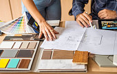 Close-up of a architect discussing building blueprints with female colleague in office