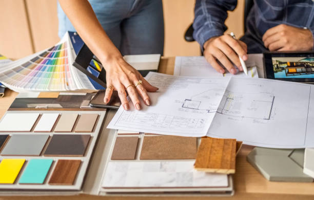 Close-up of a architect discussing building blueprints with female colleague in office Cropped shot of a male architect discussing building blueprints with female colleague during meeting in office interior designer stock pictures, royalty-free photos & images