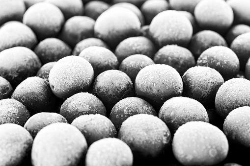 Group of frozen cherries as background. Black and white image.