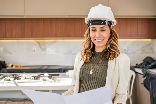 istock Successful young female architect wearing hardhat at construction site 1465654880