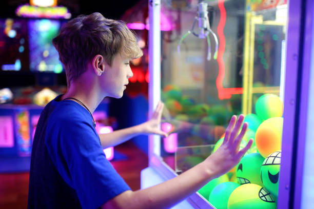 istock Kid Looking at the Toy Balls in an Arcade Claw Prize Machine Game 1465656384