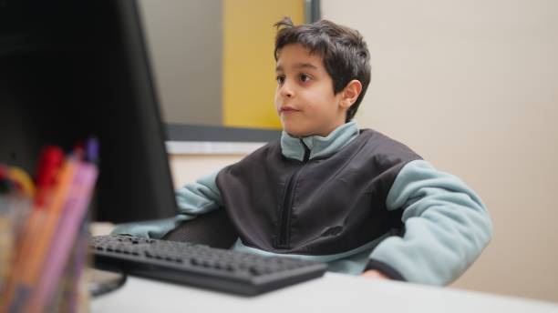niño pequeño practicando lectura rápida con tutor en la computadora - computer lab child internet development fotografías e imágenes de stock
