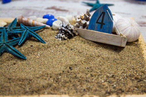 Antique spyglass, treasure map and pirate chest filled with gold and silver coins on the beach at sunset.