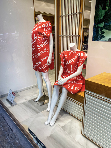 Valencia, Spain - January 17, 2023: Two mannequins in clothing store window wearing dresses with the words \