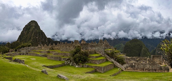 Machu Picchu, Peru, November 12, 2021: Panoramic vView of the Inca citadel Machu Picchu from 15th-century. The ancient town is located in the Eastern Cordillera of southern Peru on a 2,430-meter (7,970 ft) mountain ridge and is listed as UNESCO World Heritage Site.