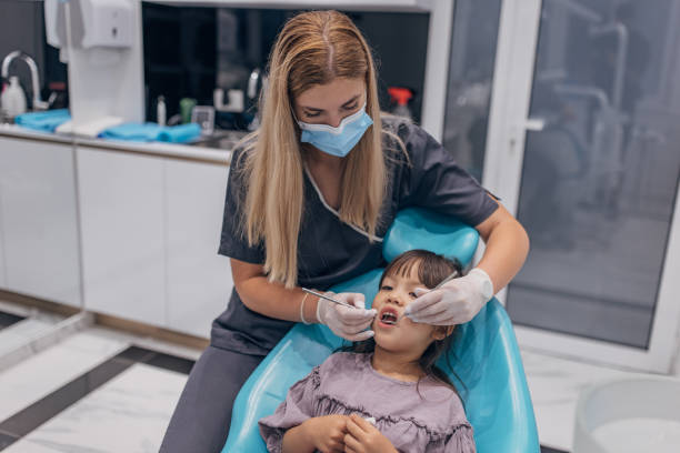 istock Female dentist examining girl's teeth 1465665476
