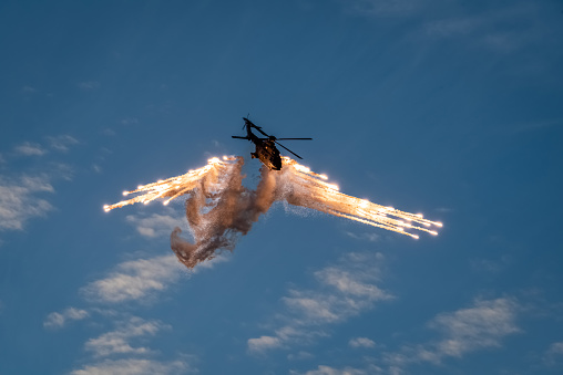 A military helicopter throws out flares during air combat