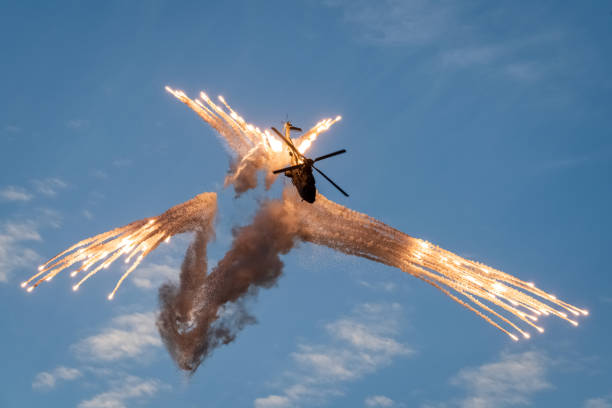 A military helicopter throws out flares during air combat