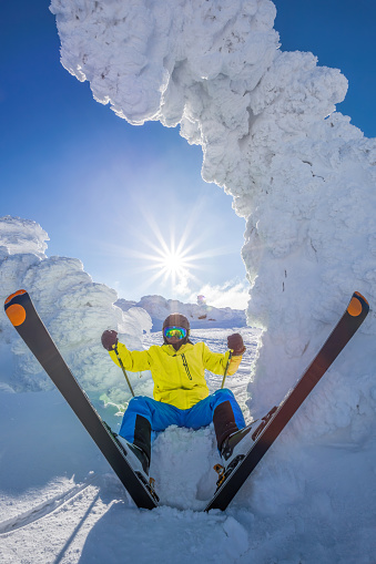 Skier is having fun during beautiful winter scenery in high mountains against sunset.