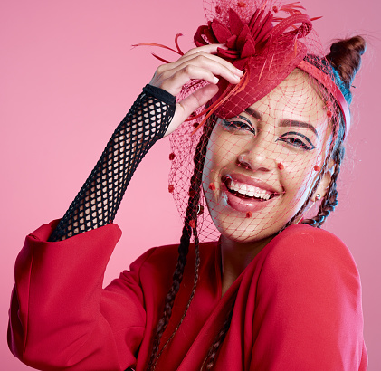 Portrait, style and woman with punk fashion feeling cheerful on a pink studio background. Fascinator, edgy and happy fashionable female with cool, creative cosmetics and makeup or beauty