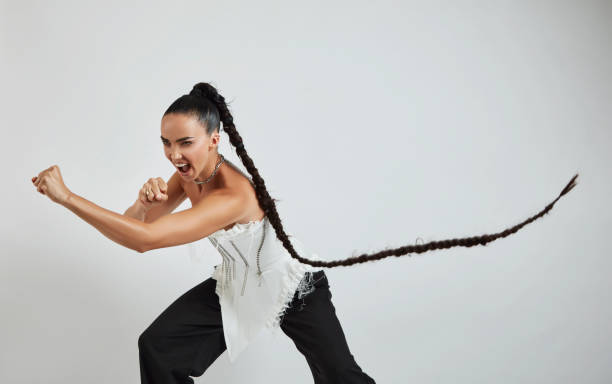 mulher bonita com cabelo trançado longo mostrando gesto de luta. - braided women sensuality portrait - fotografias e filmes do acervo