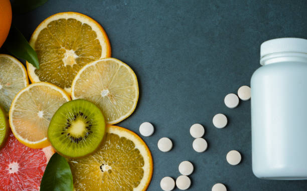 istock Vitamins. White empty bottle for vitamins on a background of citrus fruit slices. Pills. lemon. orange. Grey stone background. Blank Medicine bottle 1465671954