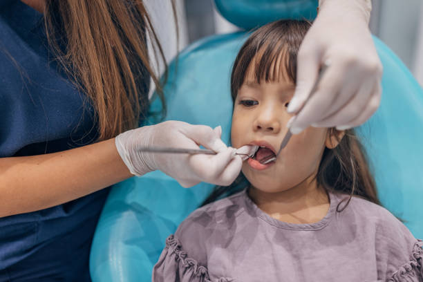 소녀의 치아를 검사하는 여성 치과 의사 - dental equipment dental drill dentist surgical mask 뉴스 사진 이미지