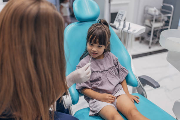istock Female dentist examining girl's teeth 1465672929