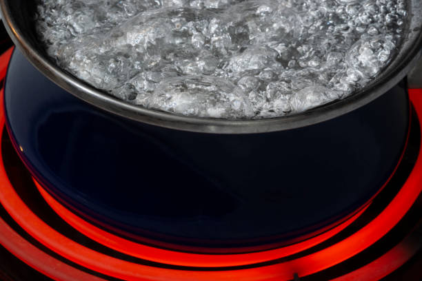 Close-up of Water Boiling In Pan on Stove Top Burner stock photo