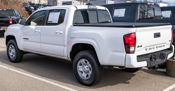 Monroeville, Pennsylvania, USA February 12, 2023 A used, white Toyota Tacoma pickup truck for sale at a dealership on a sunny winter day