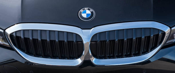 The hood of a black BMW with its emblem and grill stock photo