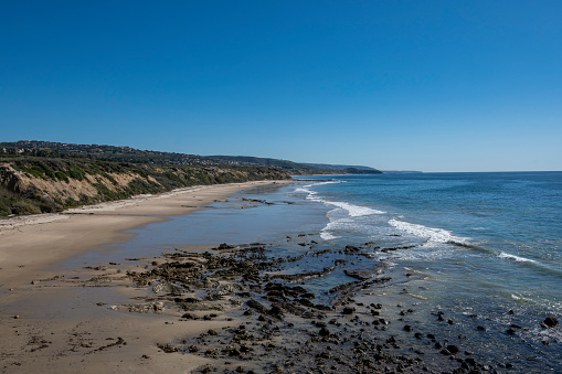 A seascape of the beach, tidal pools, and the Pacific Ocean, looking south from the Crystal Cove observation deck on the California coast.