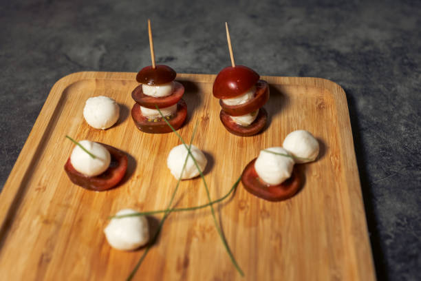 istock Buffet dish, tomatoes with mozzarella cheese on skewers, serving on a wooden substrate. 1465685450