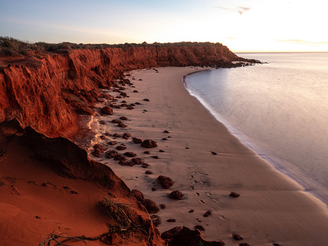 Red rocks and sandy beach at sunset in Francois Peron National Park Western Australia