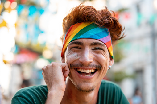 Portrait of red-haired man wearing an LGBT headband
