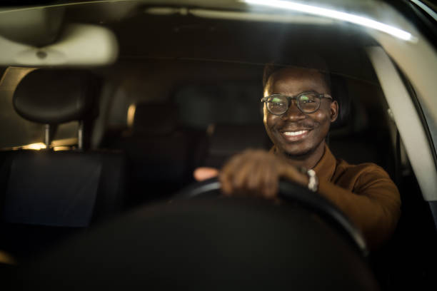Handsome African American man driving his car. stock photo