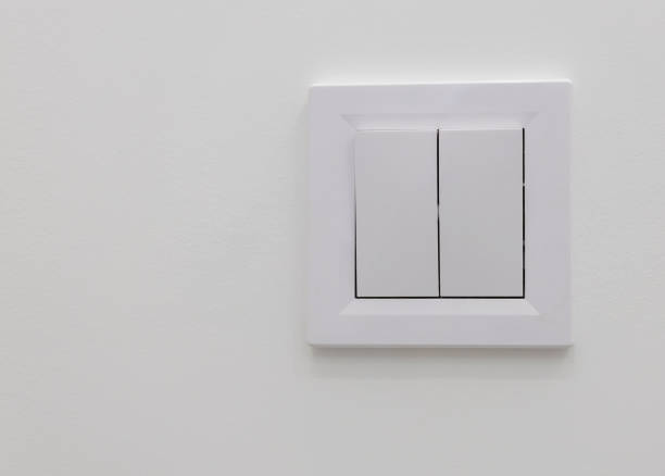 istock A white wall inside a room with a light switch. Turn off the lights, house, copy space. Concept of energy saving. 1465685919