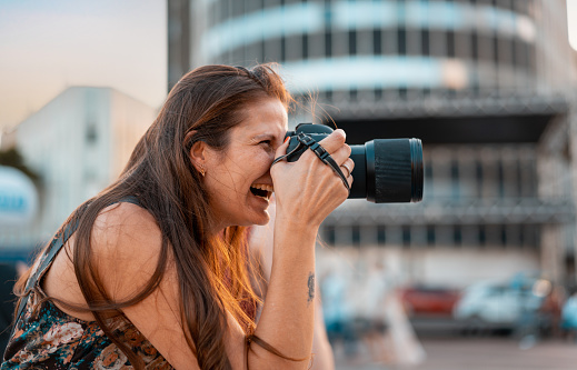 Woman photographer taking pictures outdoors