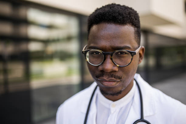 Portrait of African American healthcare worker looking at camera in front of hospital. stock photo