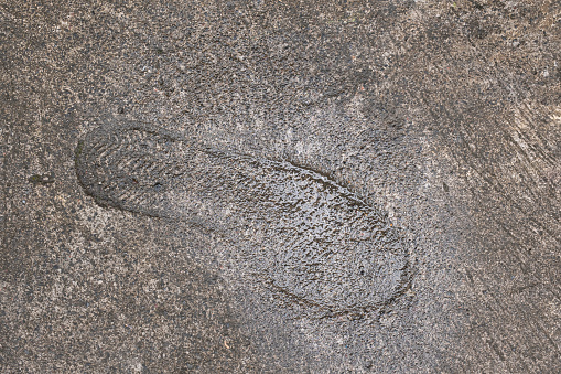 Shoe footprint in concrete pavement in Bali, Indonesia. Background and wallpaper texture