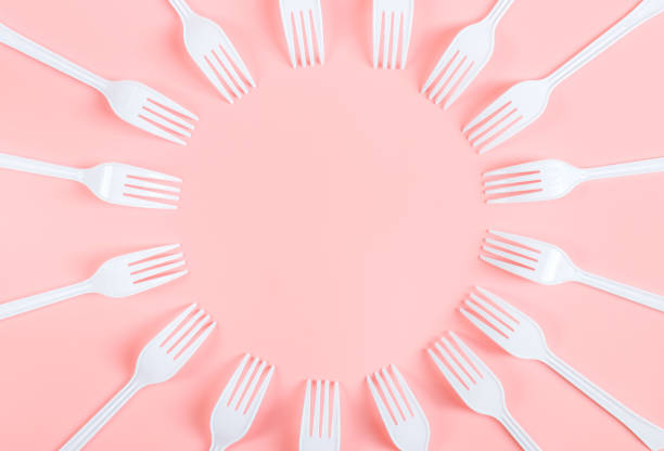 istock White plastic forks are arranged in a round frame on a light pink background. 1465694837