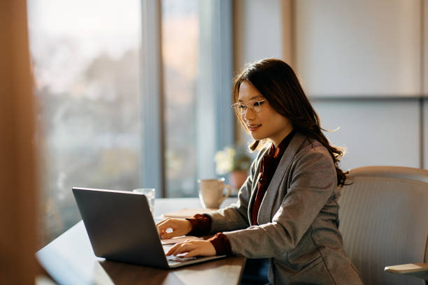istock Asian female CEO working on laptop at corporate office. 1465697096