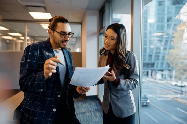istock Multiracial colleagues analyzing business reports in the office. 1465697310