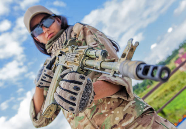 Girl with an assault rifle, strong determined, and capable woman. Holding the weapon with confidence and skill, engaged in military operation. Dressed in military gear, related to military or law enforcement.