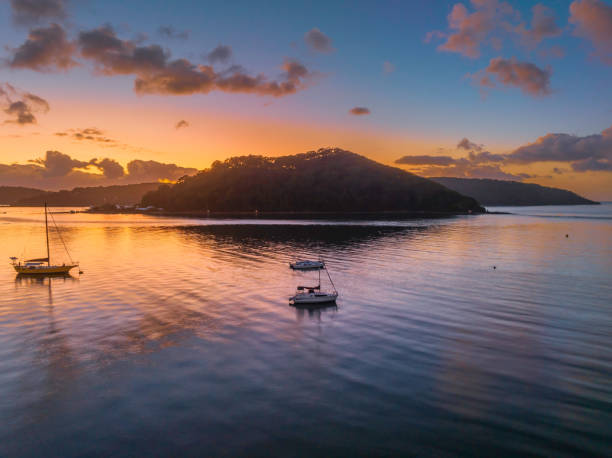 istock Sunrise over the water with clouds and boats 1465704380