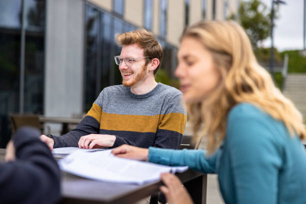Friends studying at a table outdoors at college