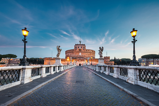 Castel Sant'Angelo and Ponte Sant'Angelo in downtown Rome Italy at twilight blue hour.